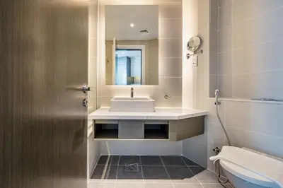 a bathroom with a sink and a mirror and a toilet at ALiving Chic Studio Apartment I Partial Burj Khalifa & Canal View I DAMAC Maison Prive B- 1417 in Dubai
