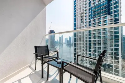 a balcony with a desk and a laptop on it at ALiving Chic Studio Apartment I Partial Burj Khalifa & Canal View I DAMAC Maison Prive B- 1417 in Dubai
