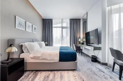 a bedroom with a bed and a desk and a television at ALiving Chic Studio Apartment I Partial Burj Khalifa & Canal View I DAMAC Maison Prive B- 1417 in Dubai