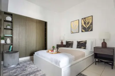 a bedroom with a large bed with a table on it at Frank Porter - The Lofts Central Tower in Dubai