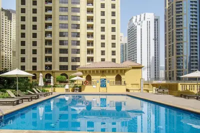 a large swimming pool in a city with tall buildings at Frank Porter - Sadaf 6 in Dubai