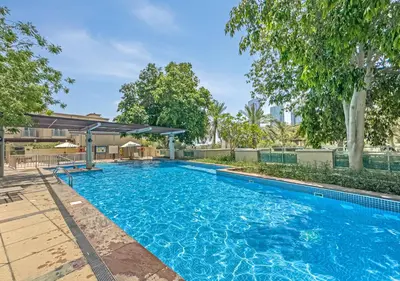 a swimming pool in a yard with trees at 2BR Dubai Marina Apt - Walk to Metro - Pool and Gym in Dubai