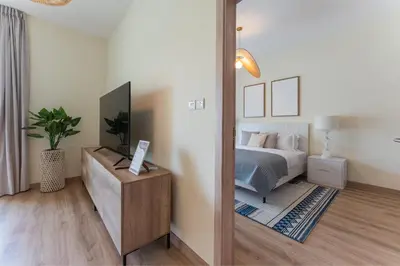 a bedroom with a bed and a mirror at HAVN - 1 Bedroom in The Greens, Barsha Heights in Dubai