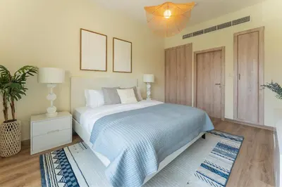 a bedroom with a bed and a potted plant at HAVN - 1 Bedroom in The Greens, Barsha Heights in Dubai