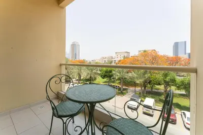 a balcony with a table and chairs and a window at HAVN - 1 Bedroom in The Greens, Barsha Heights in Dubai