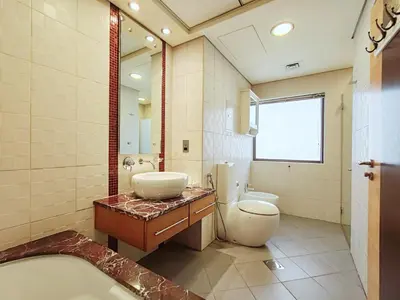 a bathroom with a tub and a toilet and a sink at ELAN RIMAL MURJAN Suites in Dubai