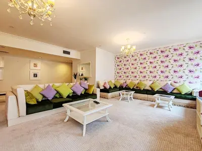 a living room with a black couch with colorful pillows at ELAN RIMAL MURJAN Suites in Dubai