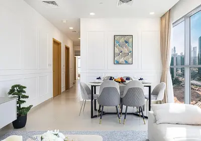 a dining room with white walls and a table and chairs at Magnificent 4 Bedroom Apartment, Bellevue Tower in Dubai