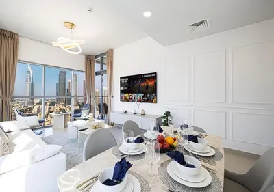 a living room with a table and chairs and a couch at Magnificent 4 Bedroom Apartment, Bellevue Tower in Dubai