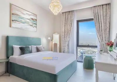 a bedroom with a large bed and a large window at Luxurious 1 Bed in Dubai Creek Harbor, Hosted by Desert City Stays in Dubai