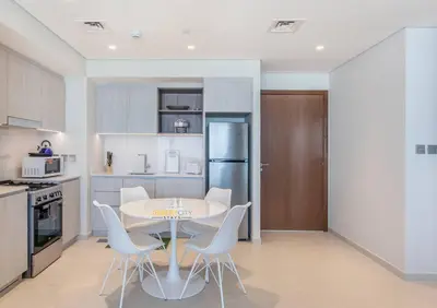 a kitchen with a table and chairs in a room at Luxurious 1 Bed in Dubai Creek Harbor, Hosted by Desert City Stays in Dubai