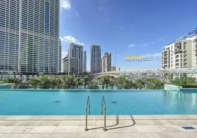 a swimming pool in a city with tall buildings at Luxurious 1 Bed in Dubai Creek Harbor, Hosted by Desert City Stays in Dubai