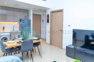 a kitchen and dining room with a table and chairs at Bloomfields 1br Azizi Gardens Meydan in Dubai