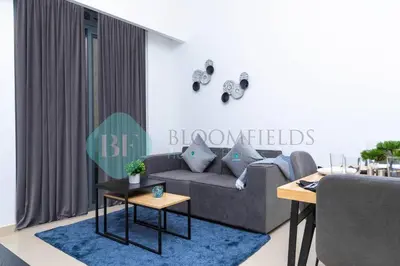 a living room with a couch and a table at Bloomfields 1br Azizi Gardens Meydan in Dubai