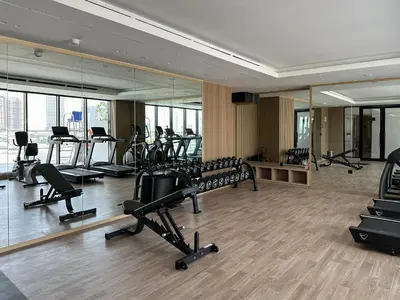 a gym with treadmills and ellipticals and mirrors at Shadow Lounge Suites Work Station & Dubai Skyline Views in Dubai