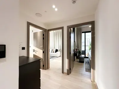 a living room with white walls and wooden floors at Shadow Lounge Suites Work Station & Dubai Skyline Views in Dubai