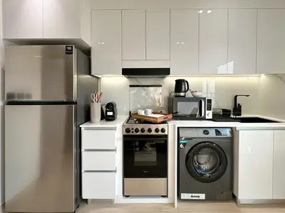 a kitchen with a stove and a washing machine at Shadow Lounge Suites Work Station & Dubai Skyline Views in Dubai