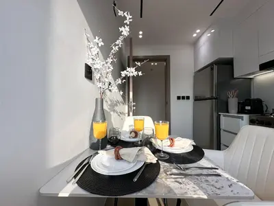 a table with two plates of food and orange juice at Shadow Lounge Suites Work Station & Dubai Skyline Views in Dubai