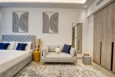 a bedroom with a bed and a chair at Elegant studio in Me Do Re Tower in Dubai