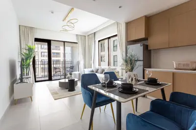 a kitchen and living room with a table and chairs at Elegant 1 Bedroom at Creek Beach Bayshore in Dubai