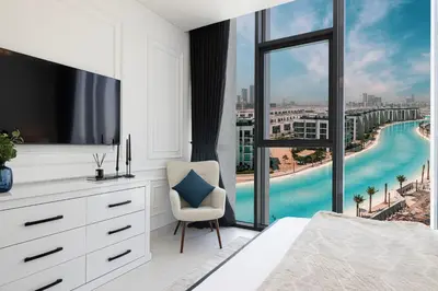 a bedroom with a bed and a tv and a window at Crystal Lagoon View Beach access Fast Wi-Fi in Dubai