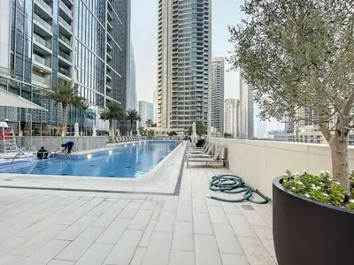 a swimming pool in a city with tall buildings at Forte Tower 2 - Warm Two Bedroom in Dubai