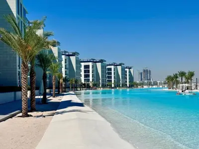 a large swimming pool with palm trees and buildings at Residences 29 - Divine Beachfront One Bedroom in Dubai