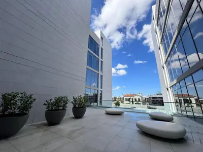 a large building with a patio with plants and benches at Residences 29 - Divine Beachfront One Bedroom in Dubai