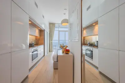 a kitchen with white cabinets and a table with a toy at Studio One - Gorgeous Studio in Dubai