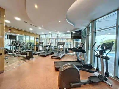 a gym with treadmills and ellipticals in a building at Ocean Heights - Exquisite One Bedroom in Dubai
