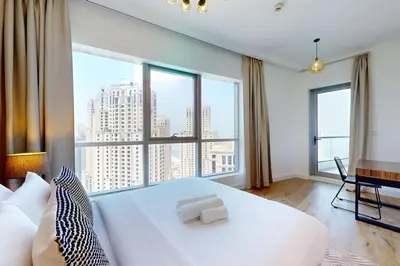 a bedroom with a large white bed and a large window at Bay Central - Enticing Two Bedroom in Dubai