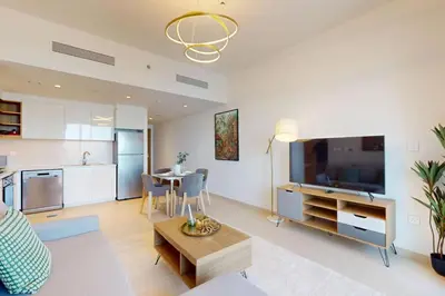 a living room with a couch and a table and a kitchen at Downtown Views II, Tower 2- Calm One Bedroom in Dubai