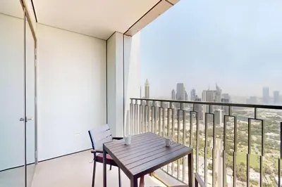 a wooden table and chair on a balcony with a view at Downtown Views II, Tower 2- Calm One Bedroom in Dubai