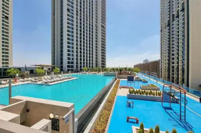 a large swimming pool in a city with tall buildings at Downtown Views II, Tower 2- Calm One Bedroom in Dubai