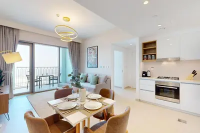 a kitchen and living room with a table and chairs at Downtown Views II, Tower 2- Calm One Bedroom in Dubai