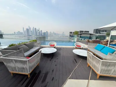 a rooftop deck with furniture and a view of the city at SevenPalm 2BR SeaView RooftopPool privBeach in Dubai