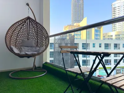 a hanging hammock on a balcony with a table at Ultra Luxury Flat Fully Upgrade with Balcony in Marina in Dubai