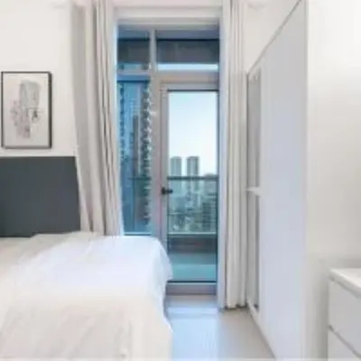 a bedroom with a bed and a sliding glass door at Best Spot in Marina Dubai in Dubai