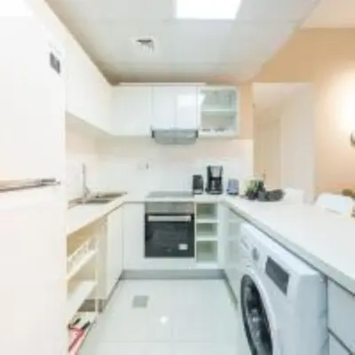 a white kitchen with a washer and a dishwasher at Best Spot in Marina Dubai in Dubai