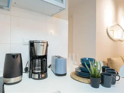 a kitchen counter with a blender and plates and cups at Best Spot in Marina Dubai in Dubai