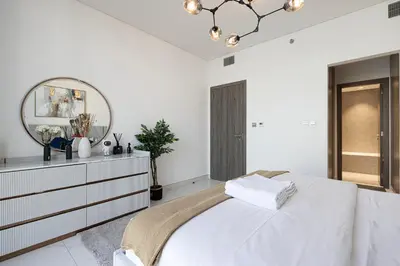 a white bedroom with a large bed and a mirror at Full Lagoon View Beach Access Exclusive building in Dubai