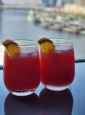 two glasses of juice with orange slices in them at Alaia Retreat in Dubai