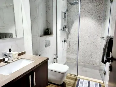 a bathroom with a shower and a toilet and a sink at Alaia Retreat in Dubai
