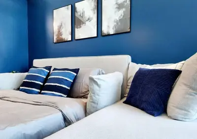 a living room with a white couch with blue walls at Alaia Retreat in Dubai