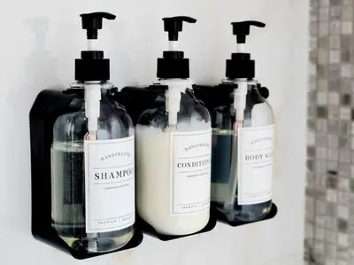 a group of three bottles of soap on a shelf at Alaia Retreat in Dubai