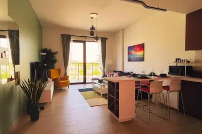a kitchen and living room with a counter and chairs at Full Seaview Comfortable Apt La Mer Dubai in Dubai