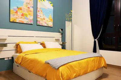 a bedroom with a bed with a yellow comforter at Full Seaview Comfortable Apt La Mer Dubai in Dubai