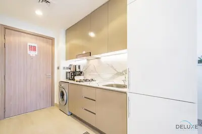 a kitchen with a sink and a washing machine at Attractive Studio Apartment in Azizi Riviera 15, Al Merkadh by Deluxe Holiday Homes in Dubai