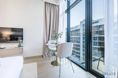 a living room with a table and chairs and a large window at Attractive Studio Apartment in Azizi Riviera 15, Al Merkadh by Deluxe Holiday Homes in Dubai