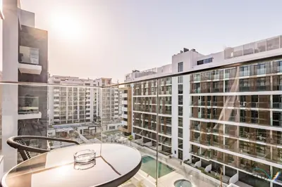 a balcony with a table and some buildings at Attractive Studio Apartment in Azizi Riviera 15, Al Merkadh by Deluxe Holiday Homes in Dubai